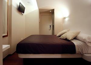 a bedroom with a large bed with a television on the wall at Pensión Iturriza in Donostia-San Sebastián