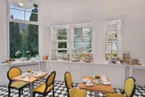 ボンにあるBoutiquehotel Dreesen - Villa Godesbergのダイニングルーム(テーブル2台、椅子、窓付)