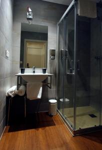 a bathroom with a sink and a glass shower at Pensión Iturriza in Donostia-San Sebastián