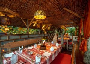 un restaurant avec des tables, des chaises et un lustre dans l'établissement Mediterraneo Boutique Hotel, à Dar es Salaam