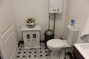 een badkamer met een toilet en een vaas met bloemen bij Furrows Lodge in Nieu-Bethesda
