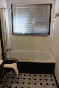 baño con bañera, ventana y lavamanos en Furrows Lodge, en Nieu-Bethesda