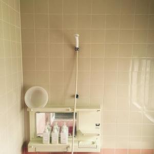 a bathroom with a shelf with bottles on it at Kusatsu KOTODAMA in Kusatsu