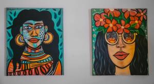 two paintings of a woman with a flower on her head at SANSE Boutique Hotel in El Nido