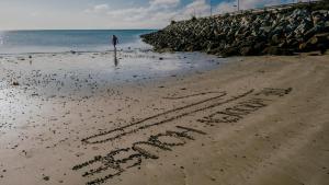 uma palavra escrita na areia numa praia em The Wooden House - Room Only Accomodation em Kilmore Quay