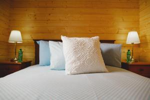 a bedroom with a white bed with two lamps at Cosy Log Cabin - The Dookit - Fife in Markinch