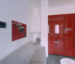 ein Wohnzimmer mit einem Sofa und einem roten Schrank in der Unterkunft Milan Apartment Rental in Mailand