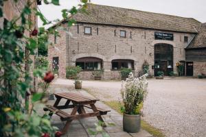 een houten picknicktafel voor een gebouw bij Black Mountain Lodge in Glasbury