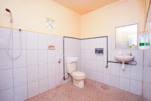 La salle de bains est pourvue de toilettes et d'un lavabo. dans l'établissement Tengger Indah Bromo Homestay at Desa Wisata Bromo Mitra RedDoorz, à Probolinggo