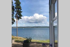 uma vista para um lago a partir de uma janela de uma casa em Nybyggd gäststuga em Berga