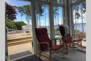 2 sillas en un porche con vistas al océano en Nybyggd gäststuga en Berga