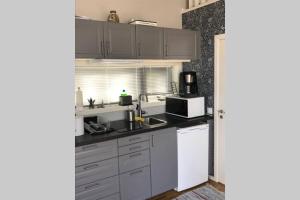 a kitchen with a sink and a microwave at Nybyggd gäststuga in Berga