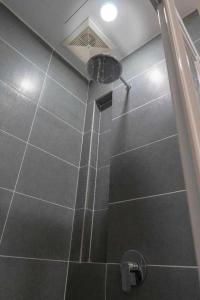 a bathroom with a shower with a tiled floor at PINTARMAN SUITES @ MIRI TIMES SQUARE in Miri