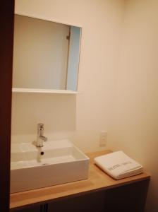 y baño con lavabo blanco y espejo. en Hotel Shun, en Nishijin