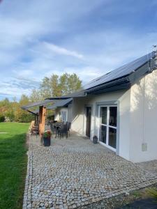 a white house with a patio and a table at Domki, apartament, pokój, Limanowa in Limanowa