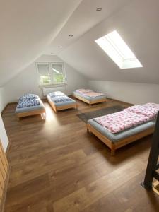 a attic room with three beds and a skylight at Domki, apartament, pokój, Limanowa in Limanowa