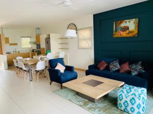a living room with a blue couch and a table at Latitude Luxury Duplex in Rivière Noire
