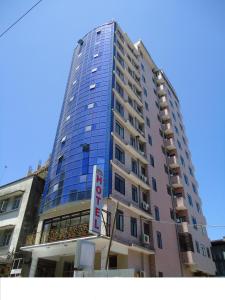 un edificio alto con un cartel delante en Rainbow Hotel en Dar es Salaam