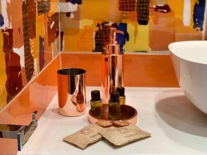 un contatore con due bottiglie di oli essenziali accanto a un lavandino di Cannone53 a Napoli