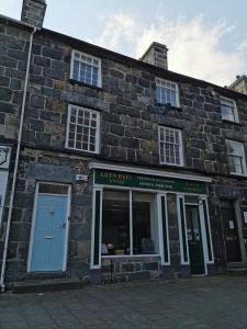 an old brick building with a blue door at Eldon Row - Stylish Character Apartments - Central Location 1 & 2 bed available in Dolgellau