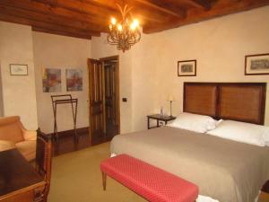 BoalにあるHotel Rural Palacio de Preloのベッドルーム1室(ベッド1台、ソファ、シャンデリア付)