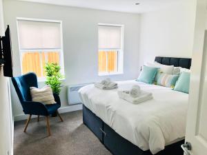 sypialnia z dużym łóżkiem i niebieskim krzesłem w obiekcie 1 2 Bedroom Shield House Apartments Sheffield Centre w Sheffield
