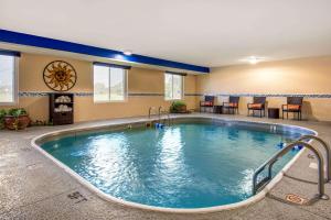 una piscina en una habitación de hotel con mesas y sillas en Quality Inn & Suites, en Brandenburg