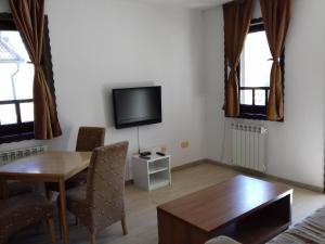 sala de estar con mesa de comedor y TV en Apartment Nice View, en Fojnica