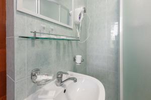 y baño con lavabo blanco y espejo. en Valensija, en Jūrmala