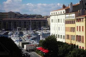 un port de plaisance avec des bateaux dans l'eau et des bâtiments dans l'établissement Appartement Hyper Centre-Vieux Port-Place aux Huiles, à Marseille