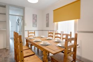 a dining room with a wooden table and chairs at STOP! Stay at The Jersey in Swansea