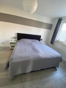 1 dormitorio con 1 cama grande en una habitación blanca en Schöne 54qm Fewo nahe Rostock und Warnemünde, en Lambrechtshagen