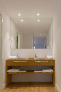 uma casa de banho com um lavatório e um espelho grande em Apartamento Alcuneza en Elmolinodelasal de Sigüenza em Sigüenza