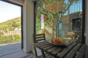 a bowl of fruit on a wooden table with a window at DouroXisto in Peso da Régua