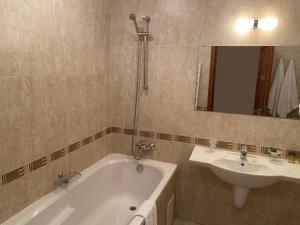 ein Badezimmer mit einer Badewanne und einem Waschbecken in der Unterkunft One Bedroom Apartment in Gated Complex in Bansko