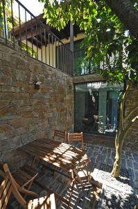 a wooden table and chairs next to a stone wall at DouroXisto in Peso da Régua