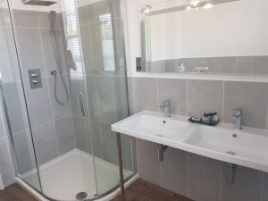 a bathroom with a shower, sink, and mirror at Best Western Moore Place Hotel in Milton Keynes