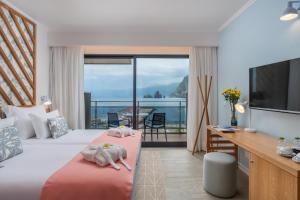 a hotel room with two beds and a balcony at Aqua Natura Bay in Porto Moniz