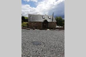 een stenen huis met een grindoprit bij Boghead Cottage: Holiday Cottage in Royal Deeside in Banchory