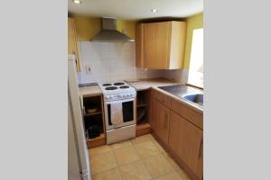 una cucina con mobili in legno e un forno a piano cottura di Boghead Cottage: Holiday Cottage in Royal Deeside a Banchory