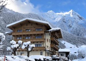 弗林肯贝格Superior Hotel Persal的一座有雪盖的建筑,有雪盖的山