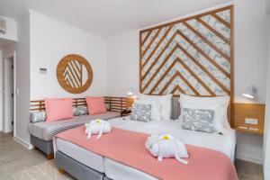 two beds in a room with pink and white at Aqua Natura Bay in Porto Moniz