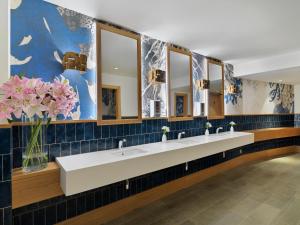 a row of sinks in a bathroom with mirrors at H10 Imperial Tarraco 4 Sup in Tarragona