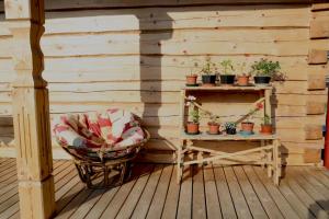 Holiday house with sauna في ريغا: شرفة مع كرسي وطاولة مع نباتات الفخار
