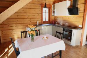 Holiday house with sauna في ريغا: مطبخ مع طاولة عليها إناء من الزهور