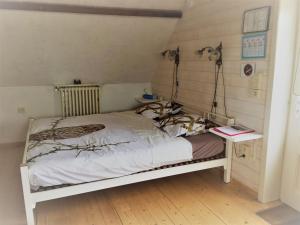 a small bed in a room with a table at Vakantiehuis Loft André in Leke