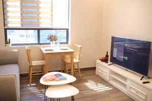 a living room with a television and a table with chairs at Lee Apartment & Hotel in Hai Phong
