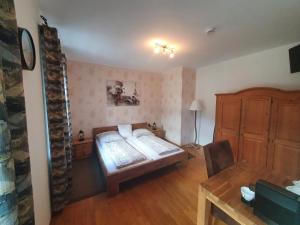 a bedroom with a bed and a desk and a table at Gasthof Alte Post in Rheinhausen