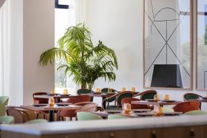 a room with tables and chairs and a potted plant at H10 Imperial Tarraco 4 Sup in Tarragona