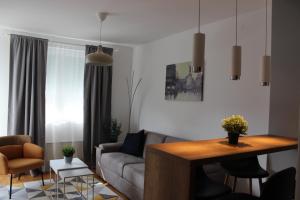 uma sala de estar com um sofá e uma mesa em Luxury apartments Free Parking em Niš